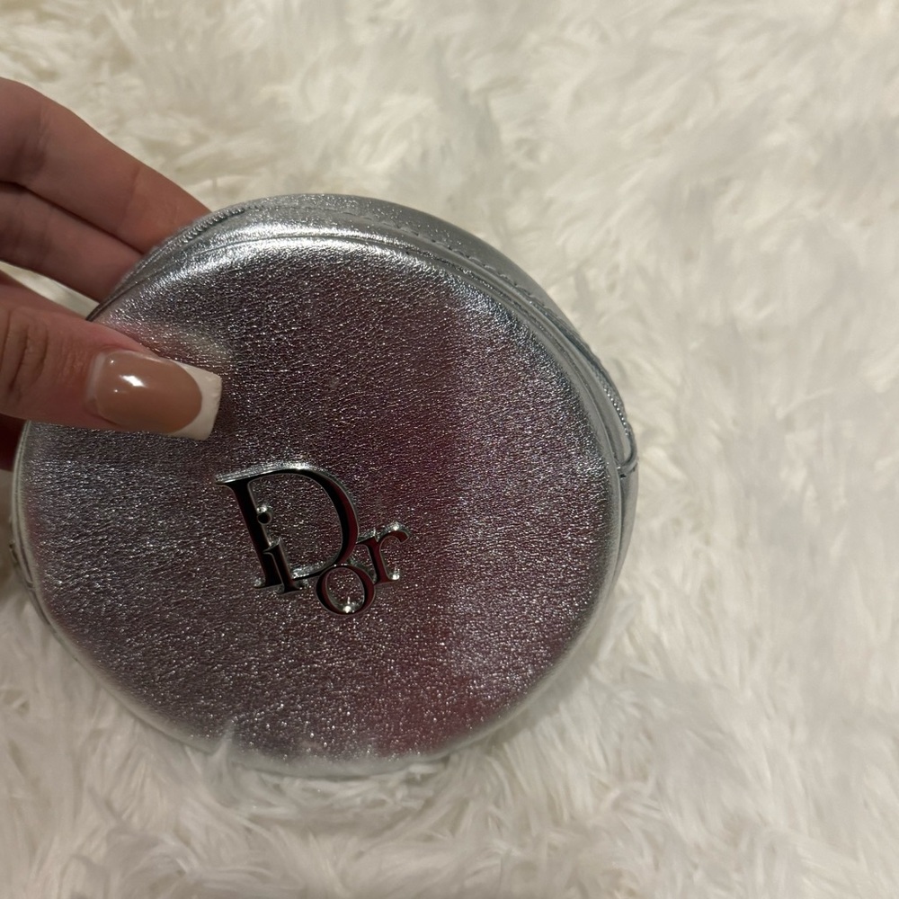 Dior Beauty silver round makeup pouch.